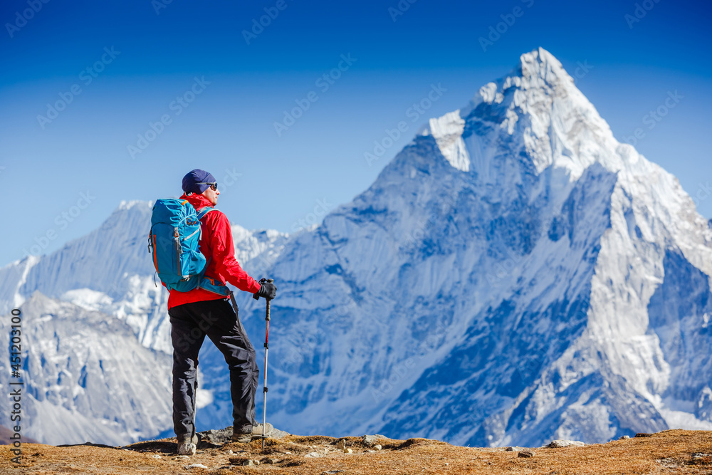 Fototapeta premium Male backpacker enjoying the view on mountain walk in Himalayas. Travel, adventure, sport concept