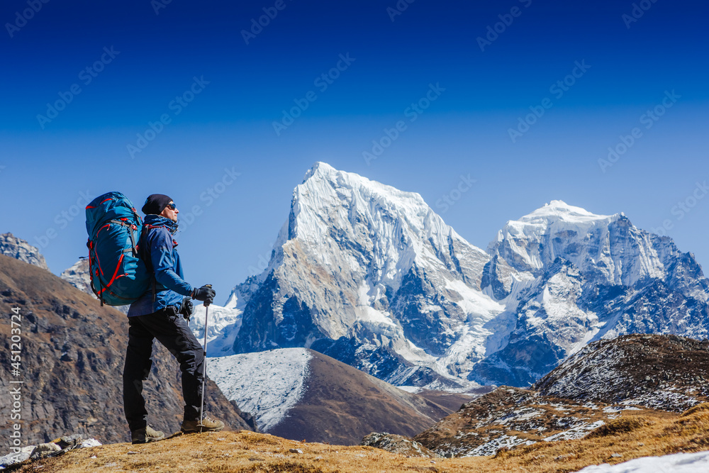 Active hiker hiking, enjoying the view, looking at Himalaya mountains landscape. Travel sport lifestyle concept. Everest base camp trek