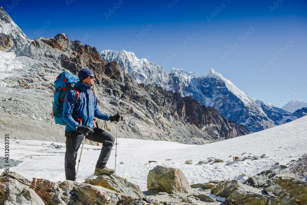 Male backpacker enjoying the view on mountain walk in Himalayas. Travel, adventure, sport concept