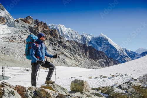 Male backpacker enjoying the view on mountain walk in Himalayas. Travel, adventure, sport concept