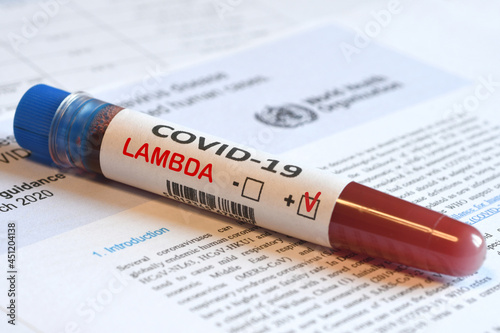Blood tube for test detection of virus Covid-19 Lambda Variant with positive result on papers document.