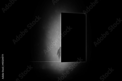 A mystical concept. Of a mysterious man silhouetted against light coming through a door. With a minimal dark edit