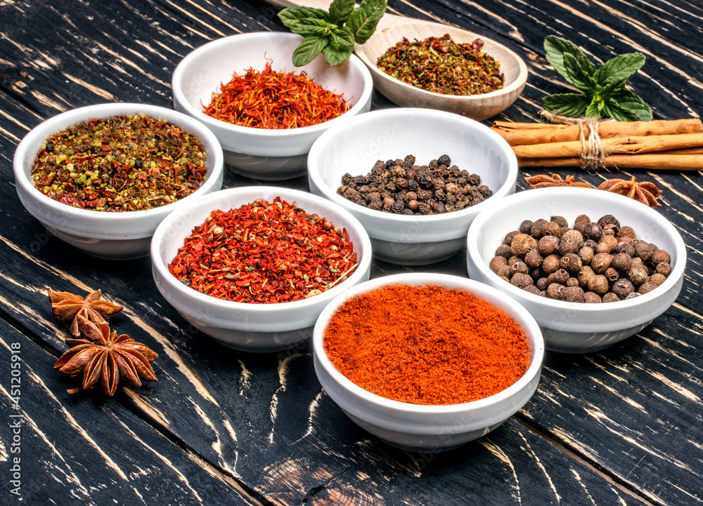 Colorful aromatic Indian spices and herbs on an old oak wooden brown backgrownd
