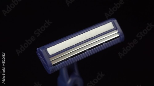 New disposable razor blade on black background. Macro shooting. Rotation photo