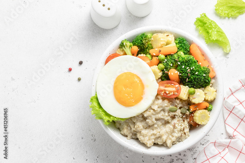 Healthy breakfast savory egg oat vegetables bowl. Space for text, top view.