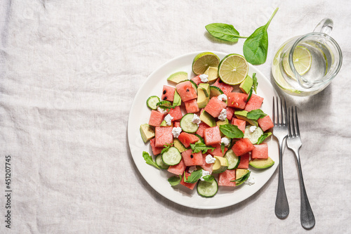 Watermelon salad with avocado, cucumber, feta cheese and arugula. Summer fruit salad. Top view, copy space