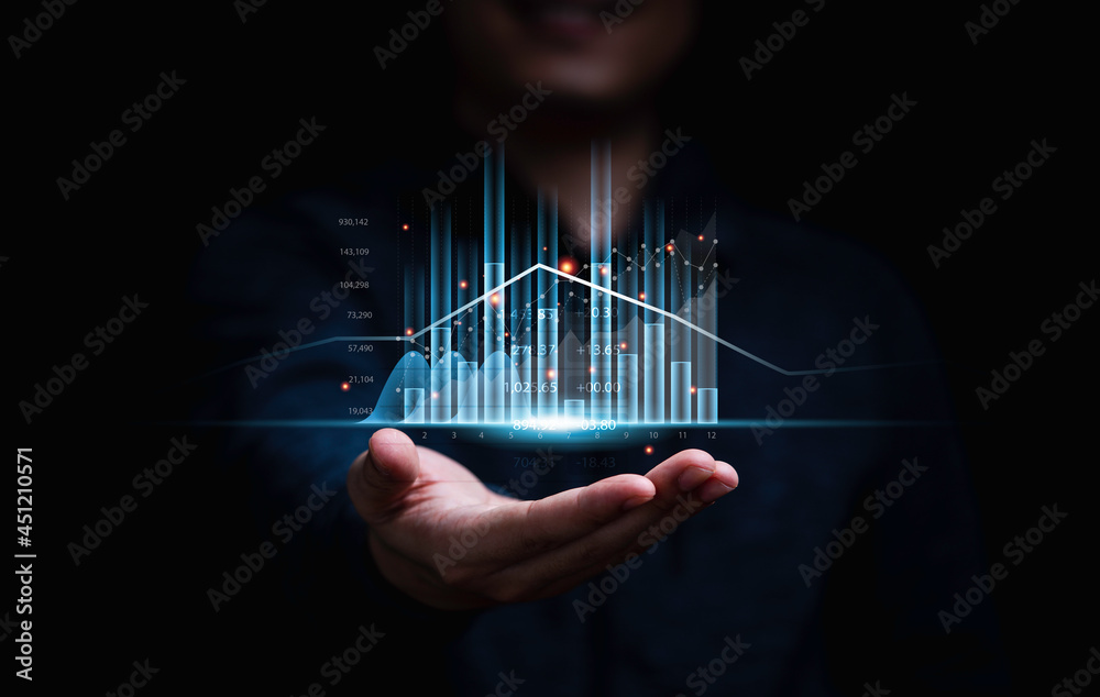 © Dilok - Businessman or trader showing glowing virtual technical investment graph chart for analysis stock market , Banking financial and planing concept.