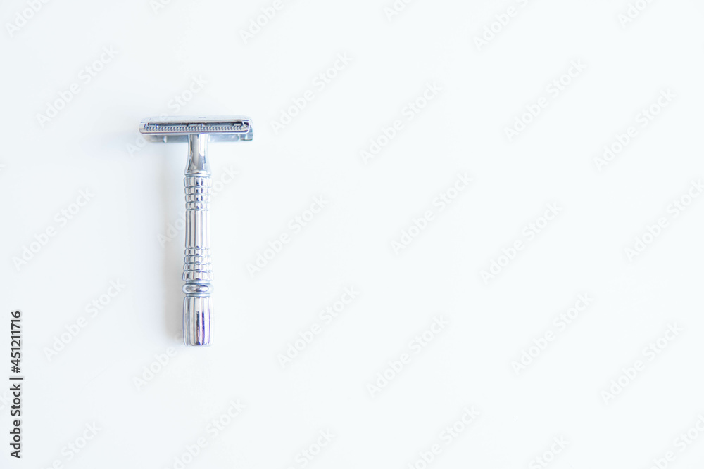 Vintage safety metal razor on a white background. Close-up. Isolated on white background. Reusable blade, zero waste product
