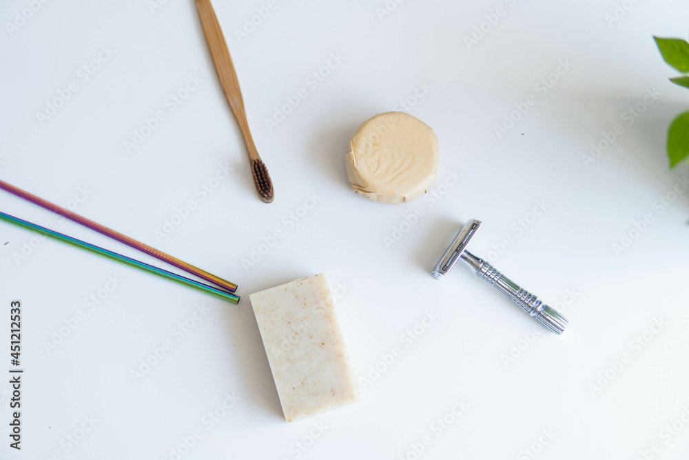 Zero waste product, close up caption. Bamboo toothbrush, solid shampoo, metal razor, metal straws and solid hand soap. Sustainable bathroom products on a white background.