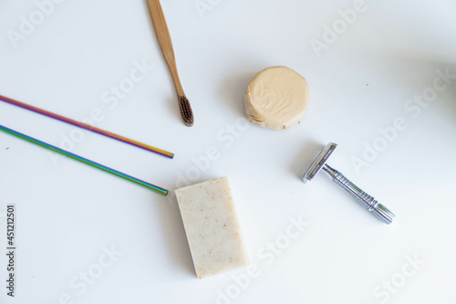 Obraz na płótnie Zero waste product, close up caption. Bamboo toothbrush, solid shampoo, metal razor, metal straws and solid hand soap. Sustainable bathroom products on a white background. w salonie