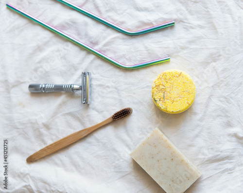 Obraz na płótnie Zero waste product, close up caption. Bamboo toothbrush, solid shampoo, metal razor, metal straws and solid hand soap. Sustainable bathroom products on a white background. w salonie