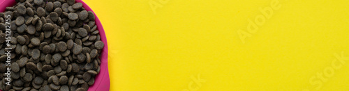 A bowl of dog food on a yellow background. Layout, banner, place for text. Flat lay.