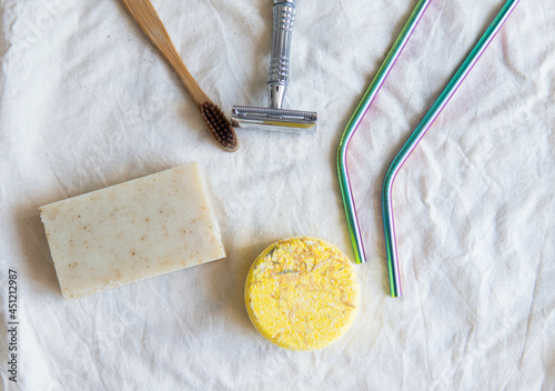 Obraz na płótnie Zero waste product, close up caption. Bamboo toothbrush, solid shampoo, metal razor, metal straws and solid hand soap. Sustainable bathroom products on a white background. w salonie