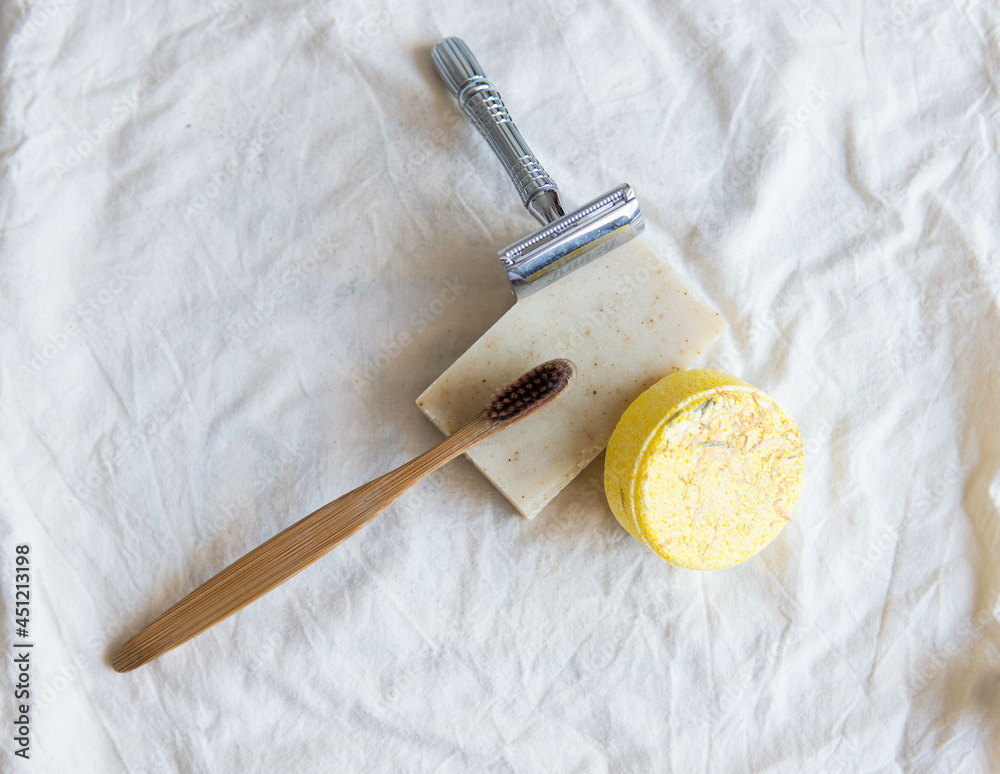 Zero waste product, close up caption. Bamboo toothbrush, solid shampoo, metal razor, metal straws and solid hand soap. Sustainable bathroom products on a white background.