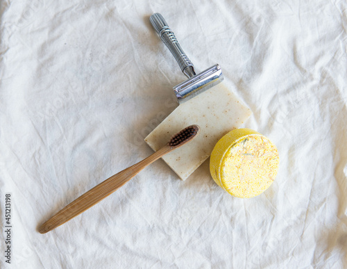 Obraz na płótnie Zero waste product, close up caption. Bamboo toothbrush, solid shampoo, metal razor, metal straws and solid hand soap. Sustainable bathroom products on a white background. w salonie