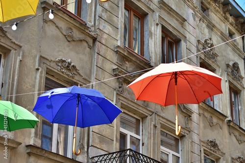 multi colored umbrellas hang on background of the old town house