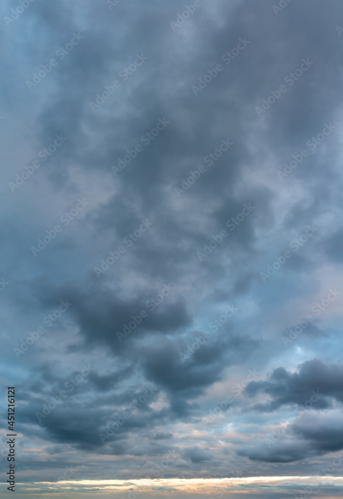 Fototapeta premium Fantastic clouds at sunrise, vertical panorama