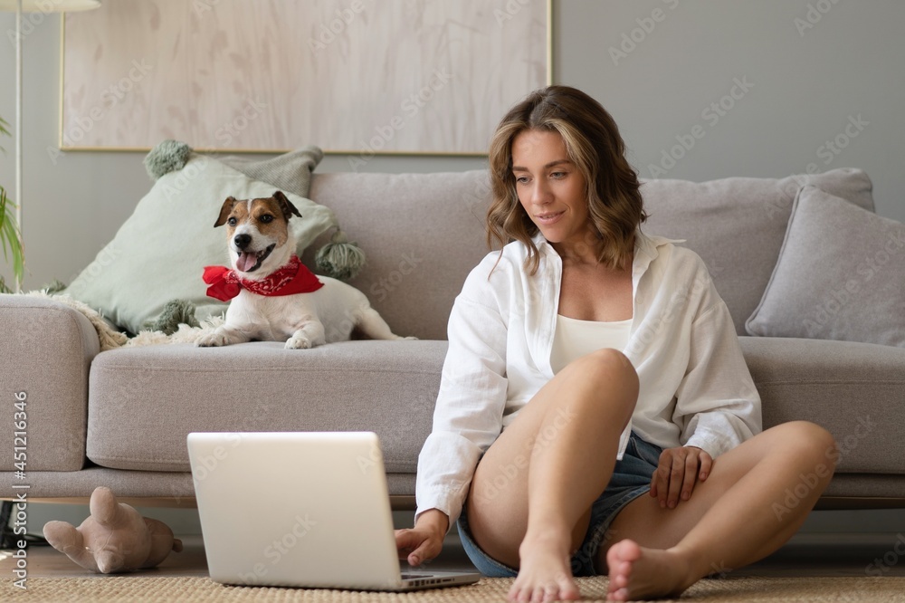 Beautiful young woman with cute dog working on laptop at home. Beautiful young woman with cute dog working on laptop at home.