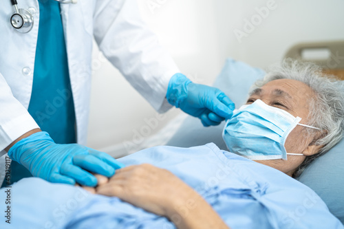 Doctor help Asian senior or elderly old lady woman patient wearing a face mask in hospital for protect safety infection and kill Covid-19 Coronavirus.