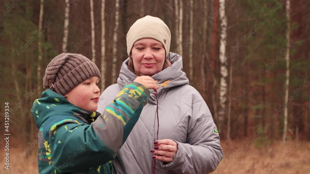 Happy mom with her son are playing with autumn foliage. The concept of a healthy lifestyle vacation in nature autumn park. At sunset, in the evening, a warm soft light. UHD 4K. Happy mom with her son are playing with autumn foliage. The concept of a healthy lifestyle vacation in nature autumn park. At sunset, in the evening, a warm soft light. UHD 4K.
