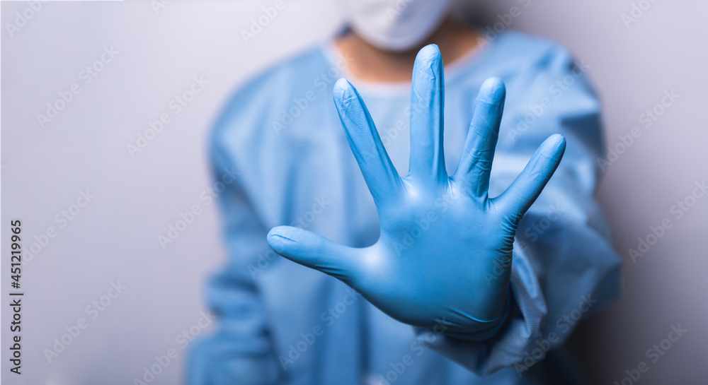 Doctor wearing protective equipment (PPE) raised her hand for dissuade or stoped, concept campaign stop virus. Doctor wearing protective equipment (PPE) raised her hand for dissuade or stoped, concept campaign stop virus.