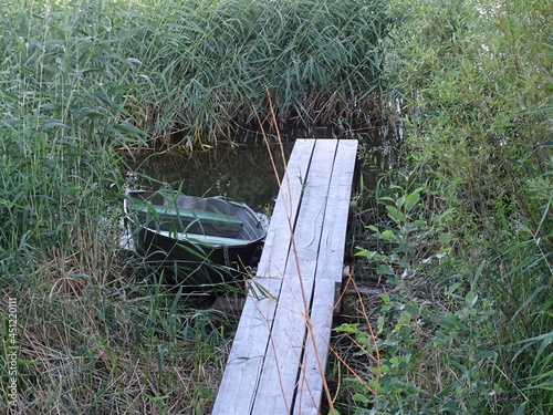 Wooden walkways by the lake and an empty boat nearby