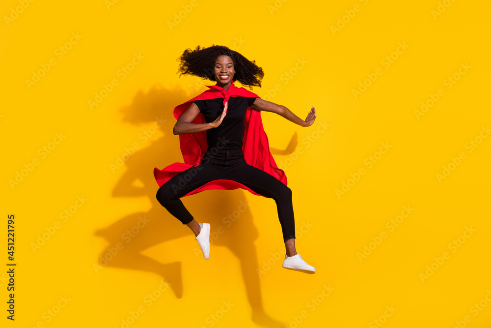 Full body photo of happy nice dark skin woman jump up wear cape super hero isolated on yellow color background