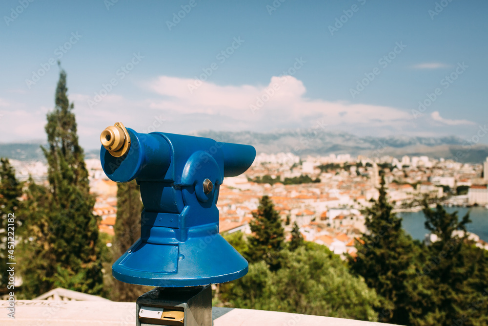 Touristic view on a coastal town from the observation point on the hill with the coin operated spyglass