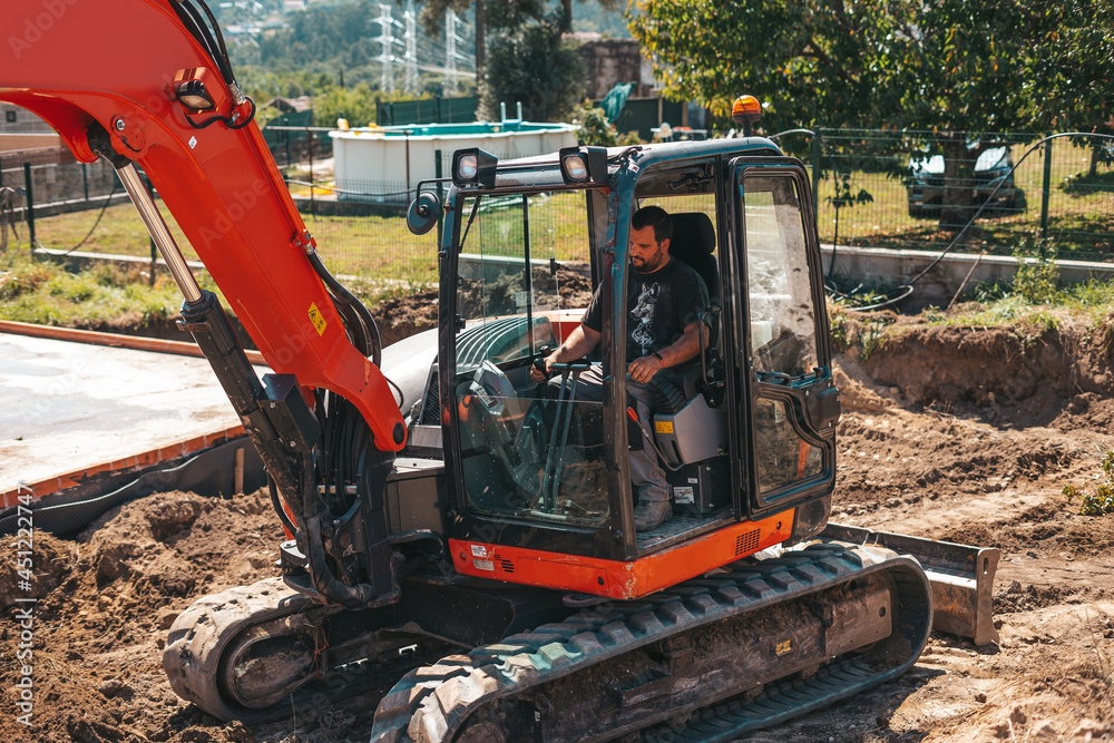 Worker driving an excavator on a construction site