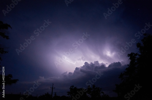 Lightning and thunderstorms in the night cloudy sky. Lightning sparkles through the clouds. Night shooting. High quality photo