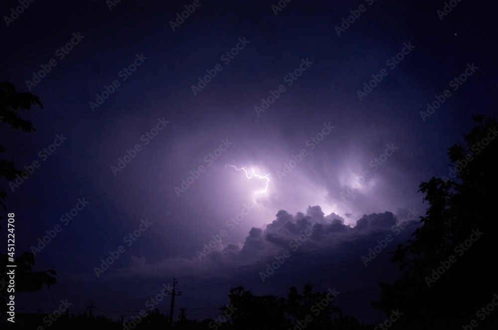Lightning and thunderstorms in the night cloudy sky. Lightning sparkles through the clouds. Night shooting. High quality photo Lightning and thunderstorms in the night cloudy sky. Lightning sparkles through the clouds. Night shooting. High quality photo