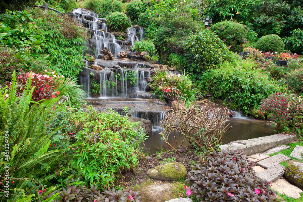 A simulated waterfall decorated with various types of flowers in the garden.