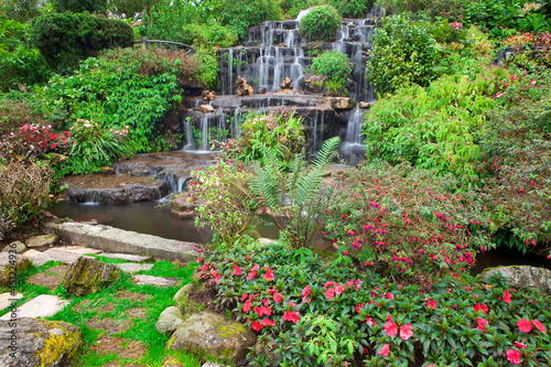 A simulated waterfall decorated with various types of flowers in the garden.