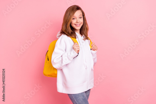 Photo portrait little girl in white hoodie smiling at school with backpack isolated pastel pink color background