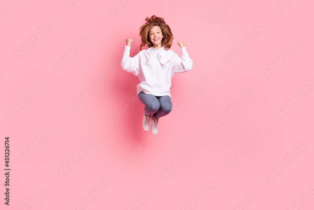 Full length body size back view girl jumping high gesturing like winner overjoyed smiling isolated pastel pink color background