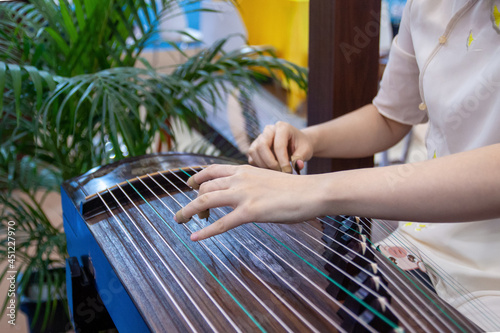 Woman hands plays the guzheng, Chinese traditional stringed musical instrument close up, Asian culture