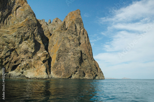 Coastal cliffs, view from the sea. Rocks in the form of animals hang over the sea. Rocky coast. Crimea.