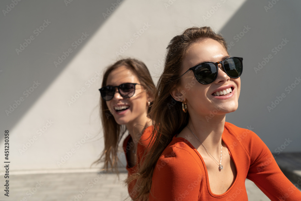 Portrait of smiling twin sisters. Enjoying their sisterhood and friendship Portrait of smiling twin sisters. Enjoying their sisterhood and friendship