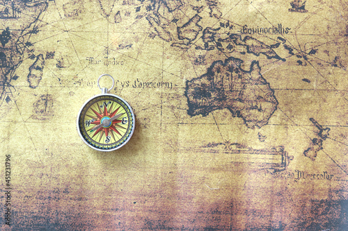 Classic round compass on background of old vintage map of world as symbol of tourism with compass  travel with compass and outdoor activities with compass