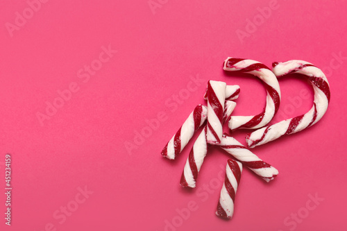 Broken candy cane and space for text on color background, top view