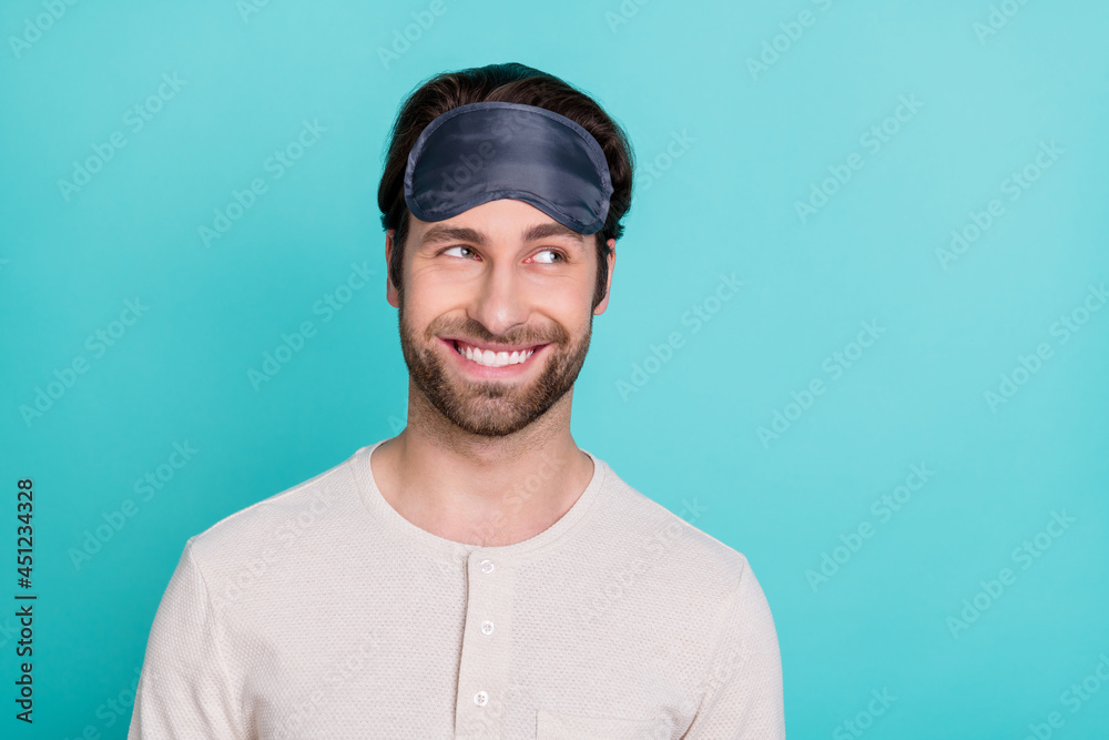 Photo of young man happy positive smile curious interested look empty space nightwear isolated over turquoise color background Photo of young man happy positive smile curious interested look empty space nightwear isolated over turquoise color background