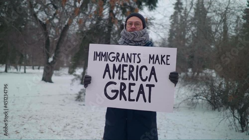 Man Stands In Winter Park And Hold A Banner. Immigrants Make America Great. Protest Against Hardline Immigration Policies. Problems Of Moving Families. Zero-tolerance. Title 42. Expelling People. photo