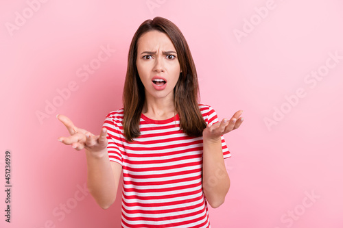 Photo of young girl unhappy angry displeased conflict argument disagreement isolated over pink color background © deagreez