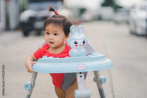 child happy time running in outdoor at road village to practice balance walk in development according to the age of the child on Baby car to help practice walking photo