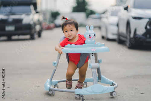 child happy time running in outdoor at road village to practice balance walk in development according to the age of the child on Baby car to help practice walking photo