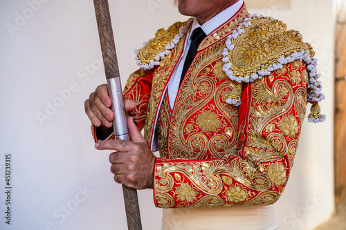Unrecognizable bullfighter in traditional costume standing with lance