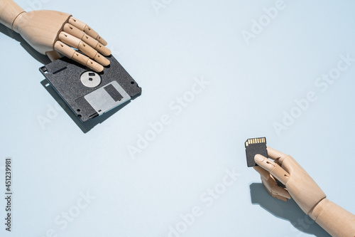 Retro floppy disk and modern memory card on blue table photo