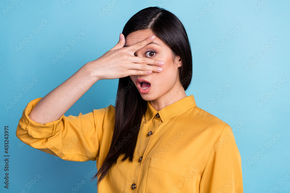Photo of young asian girl amazed shocked afraid scared hands cover face eye look isolated over blue color background Photo of young asian girl amazed shocked afraid scared hands cover face eye look isolated over blue color background