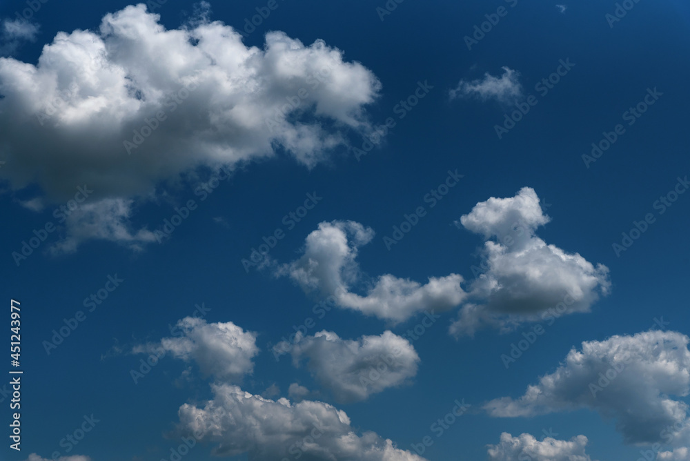 Dark blue sky and white clouds natural background. White cumulus clouds in the blue sky.