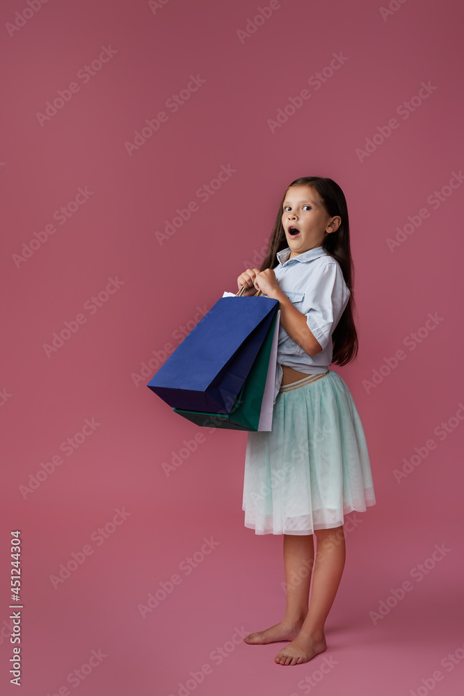 happy little child girl holds many shopping bags
